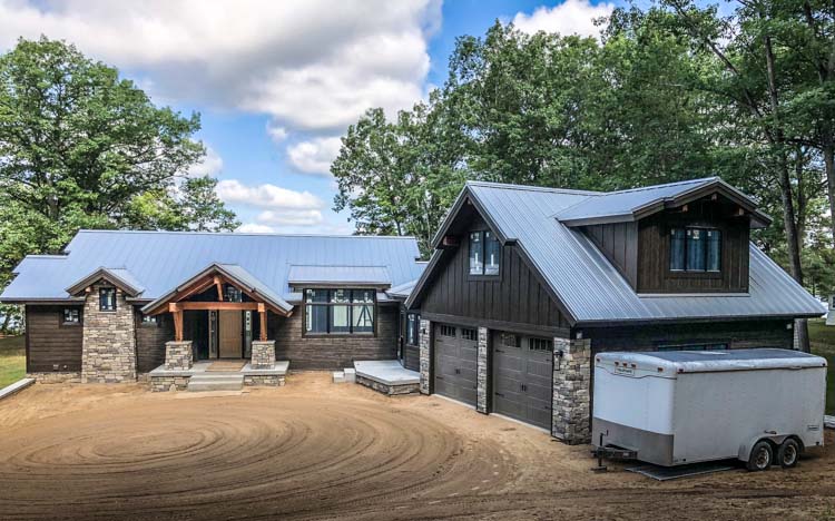 Timber home with large driveway and metal roof