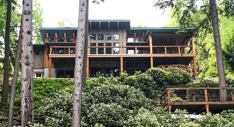 Modern timber frame home with shed roof, gardens, and a multi-level deck