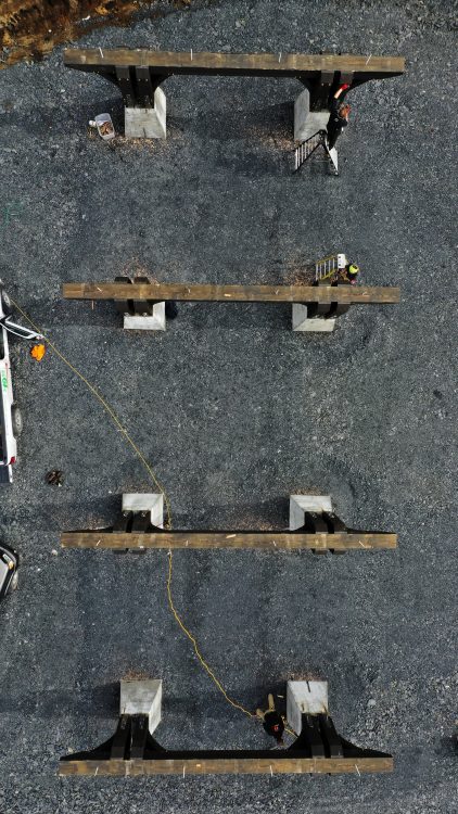 Drone photo of timber framers setting large douglas fir posts