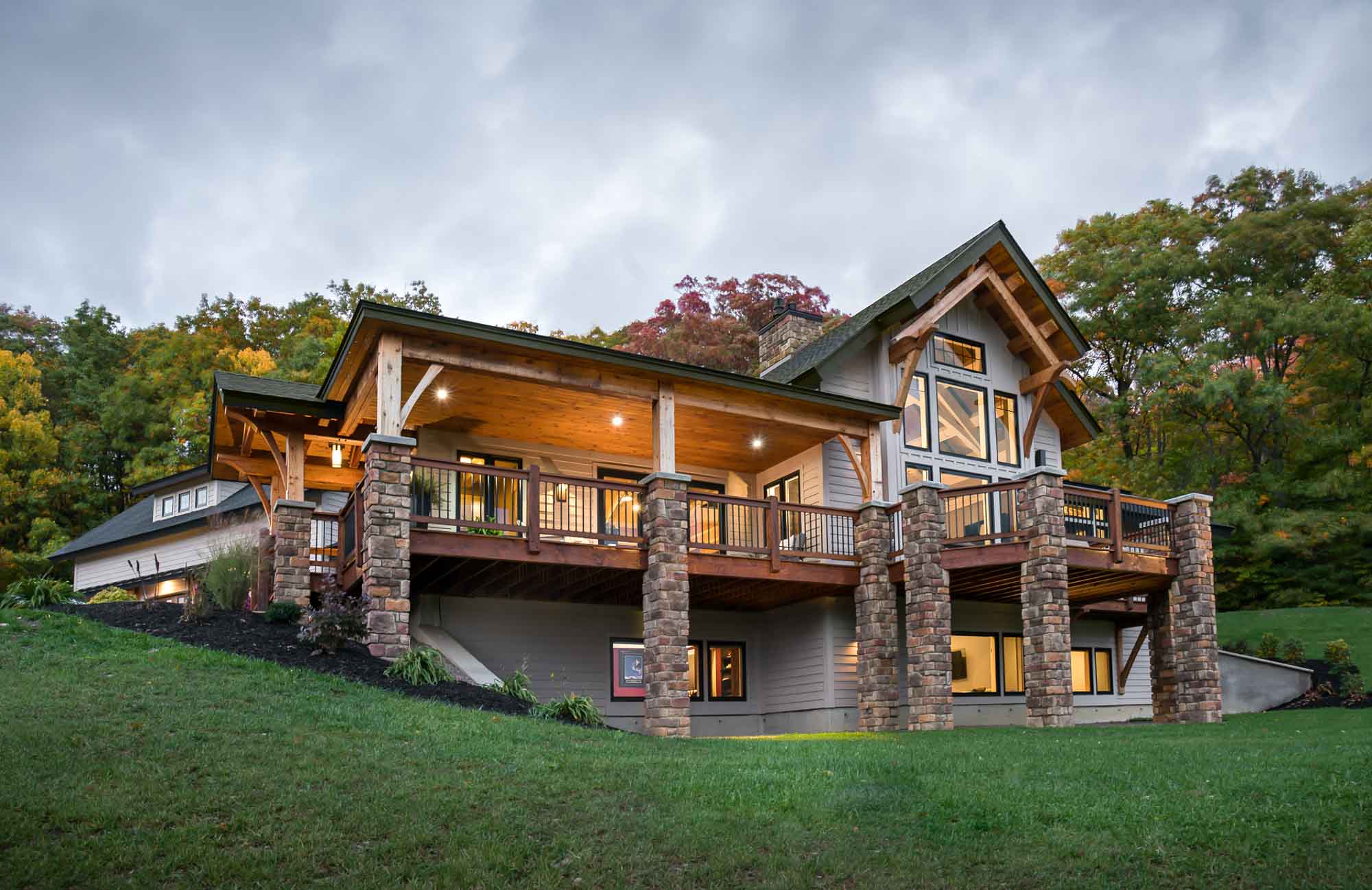 Exterior of a timber home with a large wrap around deck and flagstone posts